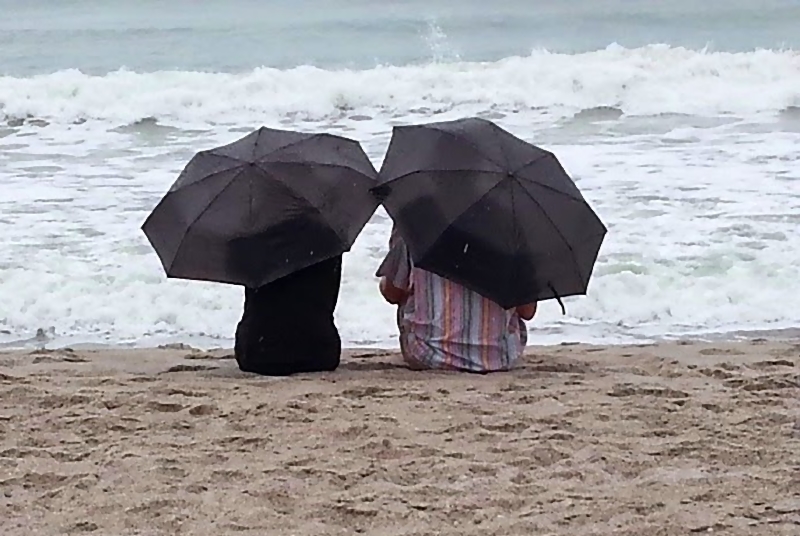 Rain beach. Дождь на море. Дождь на пляже. На пляже под дождем. Зонт на море.