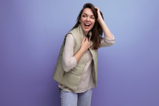 coquettish young brunette female adult in casual outfit flirting on studio background